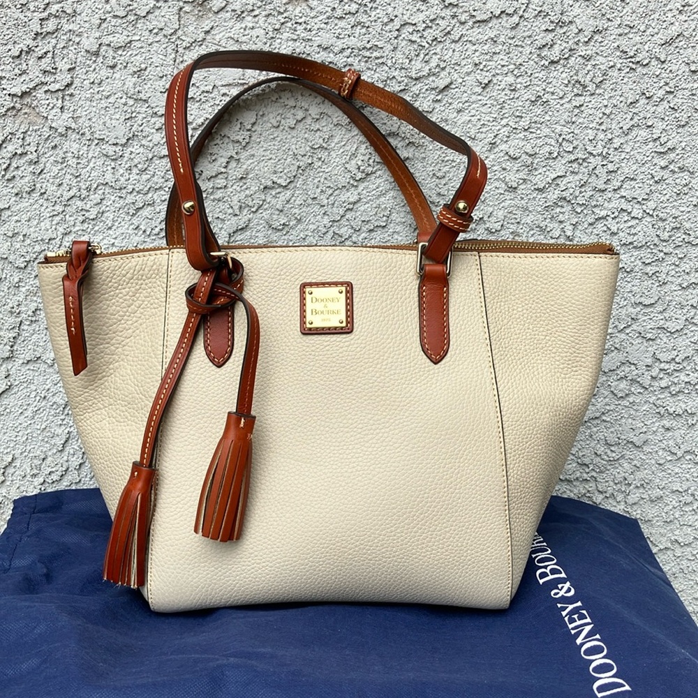 Dooney and Bourne cream handbag with brown leather handles with blue dust bag.